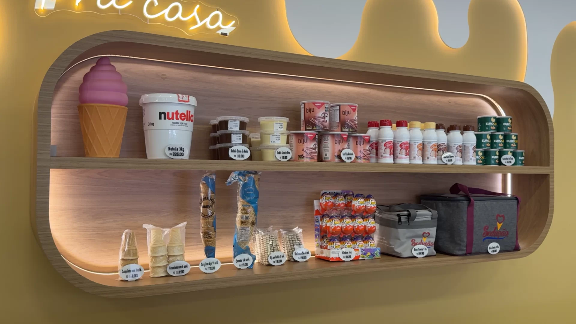 Prateleira organizada com produtos e acessórios da sorveteria
